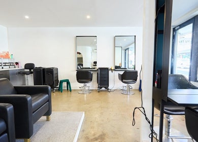 Stylish interior of Chad Wij salon in Newtown, New South Wales, AU with black chairs and modern mirrors.