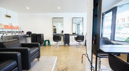 Stylish interior of Chad Wij salon in Newtown, New South Wales, AU with black chairs and modern mirrors.