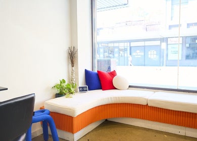 Inviting seating area at Chad Wij, Newtown, New South Wales, AU with modern decor and vibrant cushions.