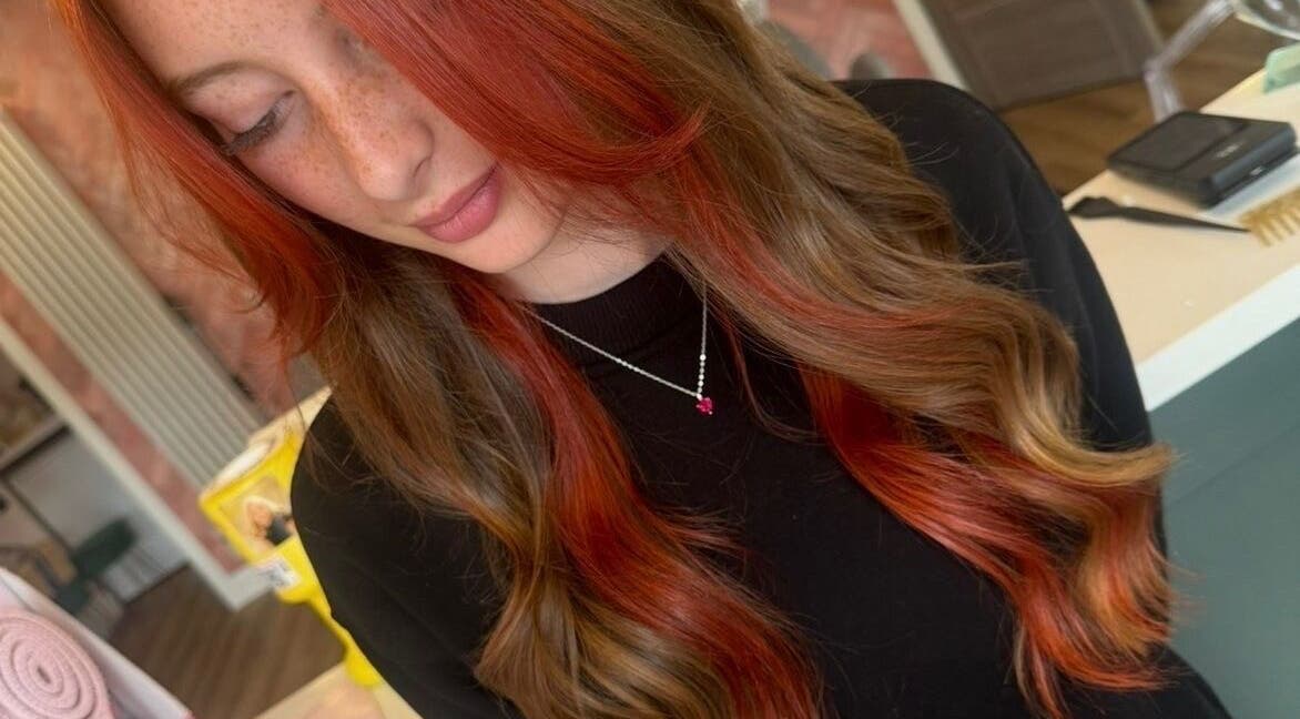 Stylish hair coloring at STUDIO 68 Hair & Nails in Portsmouth, England, GB. Showcasing vibrant red and brown waves.