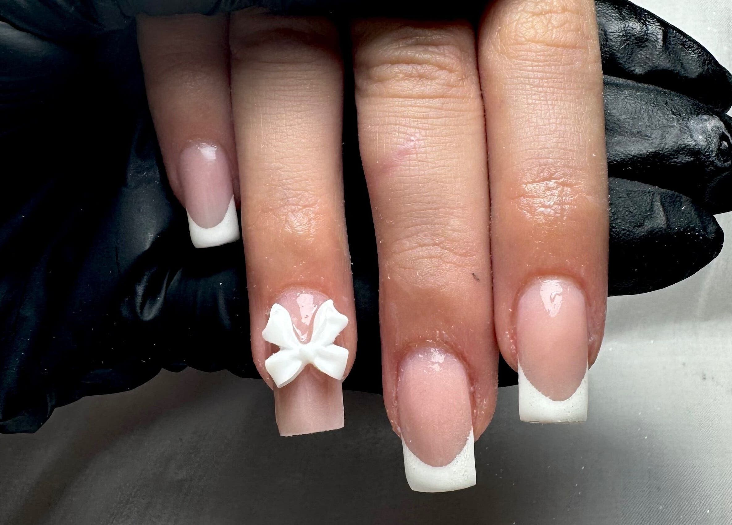 French manicure with delicate bow detail at STUDIO 68 Hair & Nails, Portsmouth, England, GB.