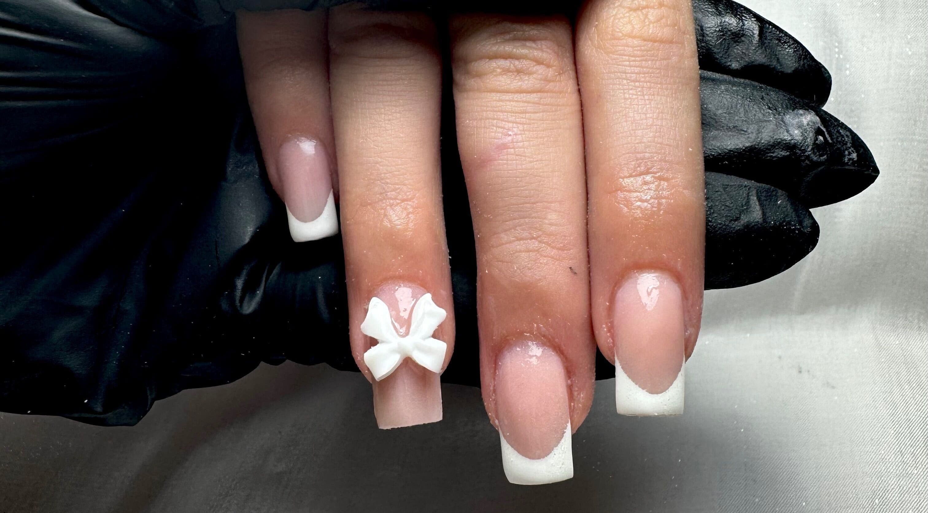 French manicure with delicate bow detail at STUDIO 68 Hair & Nails, Portsmouth, England, GB.