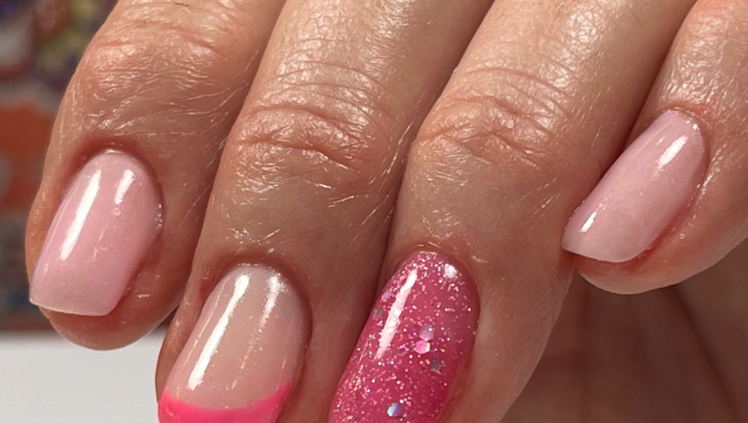 Nail art rose vif et brillant à Eloa Beauty, Genève, CH, vibrant sur des ongles soignés.