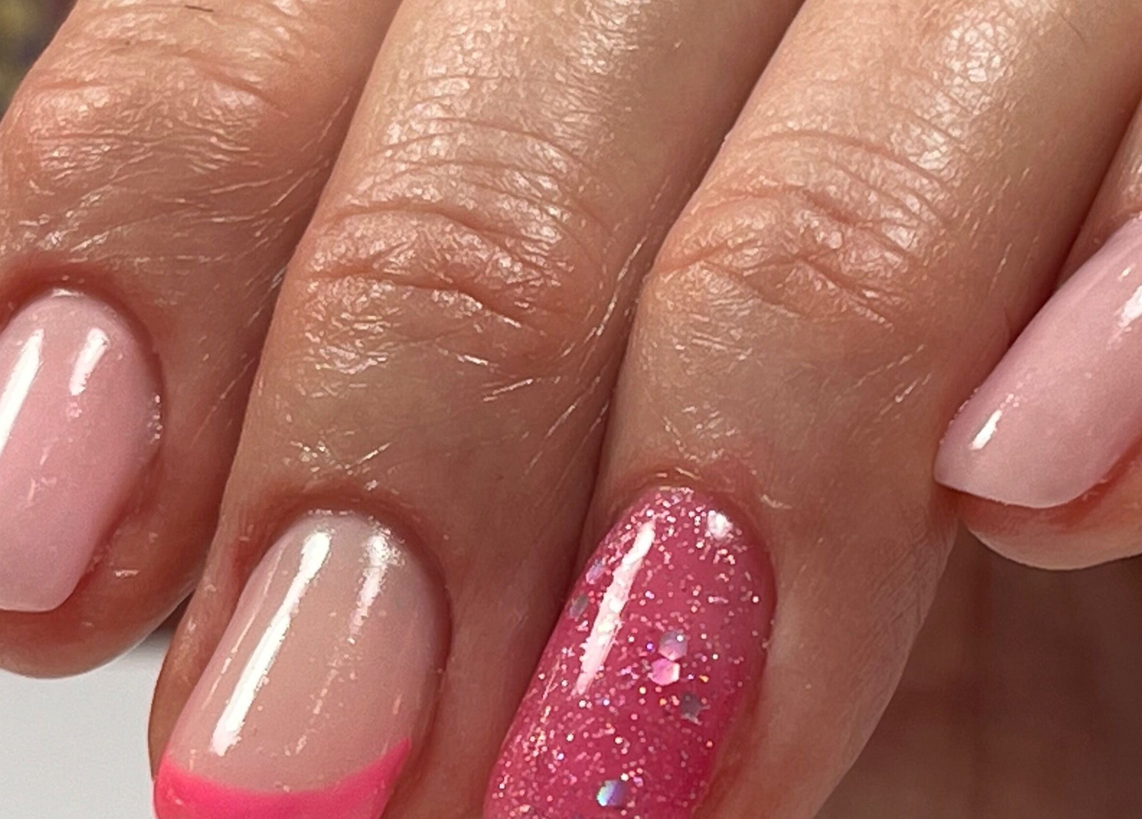 Nail art rose vif et brillant à Eloa Beauty, Genève, CH, vibrant sur des ongles soignés.