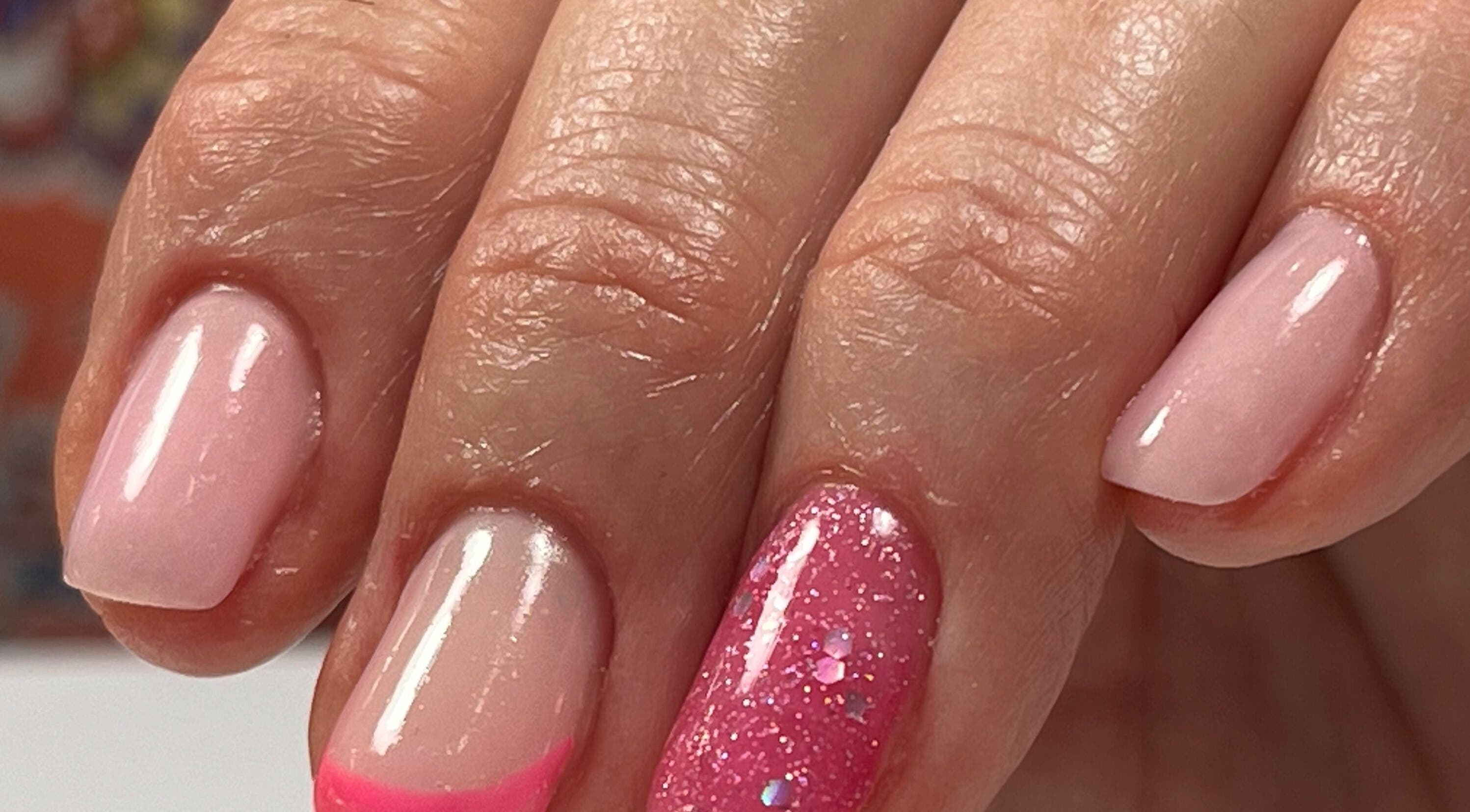 Nail art rose vif et brillant à Eloa Beauty, Genève, CH, vibrant sur des ongles soignés.