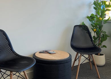 Modern seating area at Cloud Nine Beauty Studio, Tillsonburg, Ontario, CA, with black chairs and greenery.