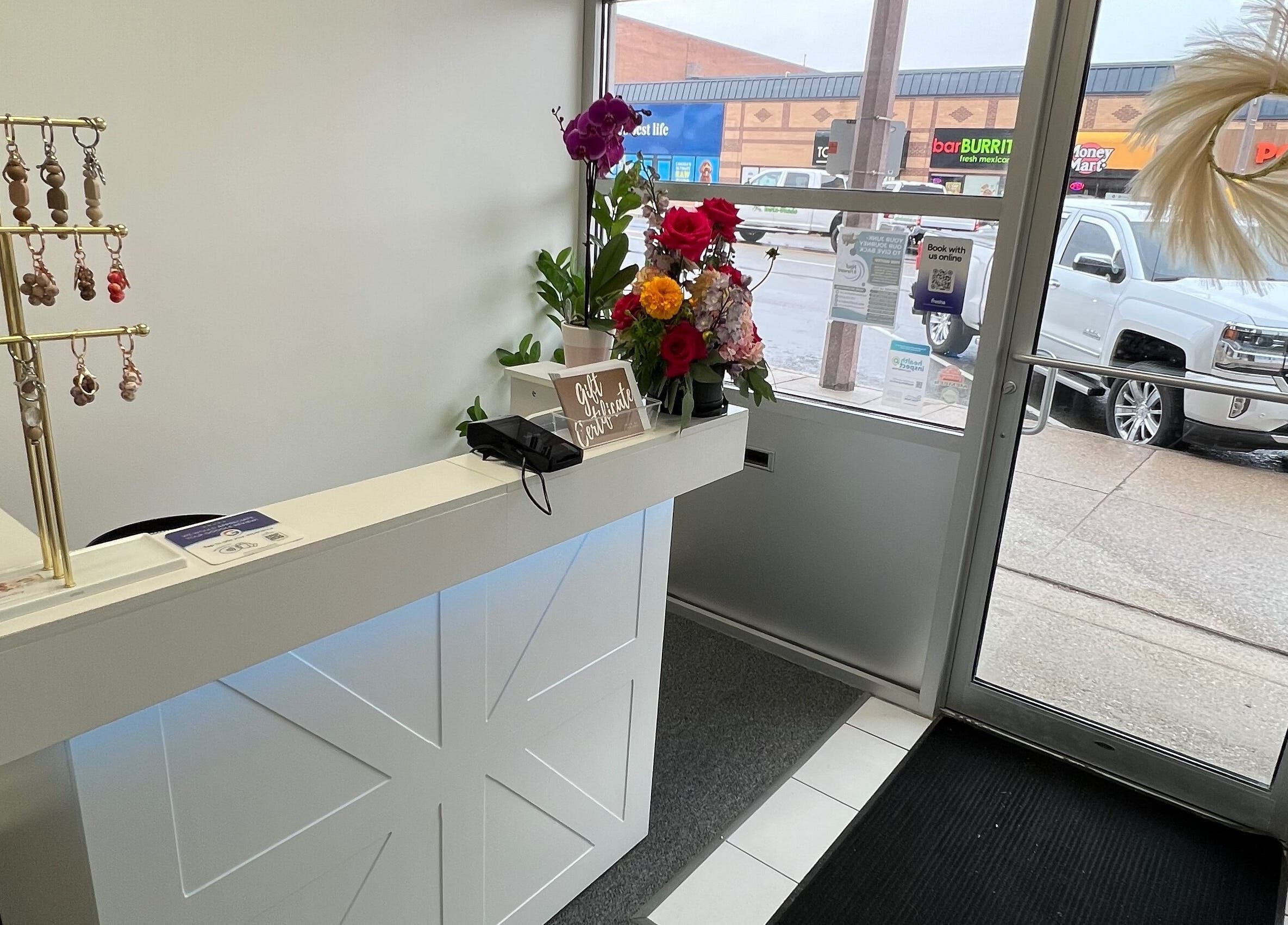 Reception area at Cloud Nine Beauty Studio in Tillsonburg, Ontario, CA with floral decor and keychains.