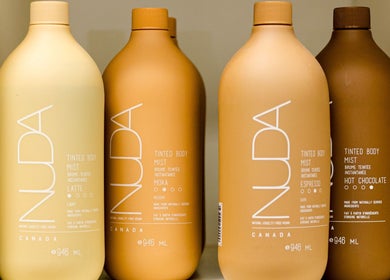 Diverse Nuda bottles at Cloud Nine Beauty Studio, Tillsonburg, Ontario, CA, showcasing premium tinted body mists.