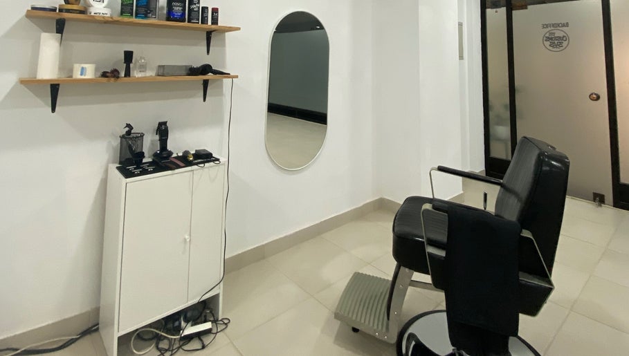 Interior moderno do STUDIO - Eduardo Victor, com espelho oval, prateleiras e cadeira estilosa em São João Da Madeira, Aveiro, PT.