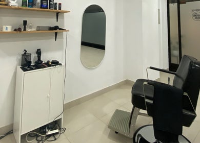Interior moderno do STUDIO - Eduardo Victor, com espelho oval, prateleiras e cadeira estilosa em São João Da Madeira, Aveiro, PT.