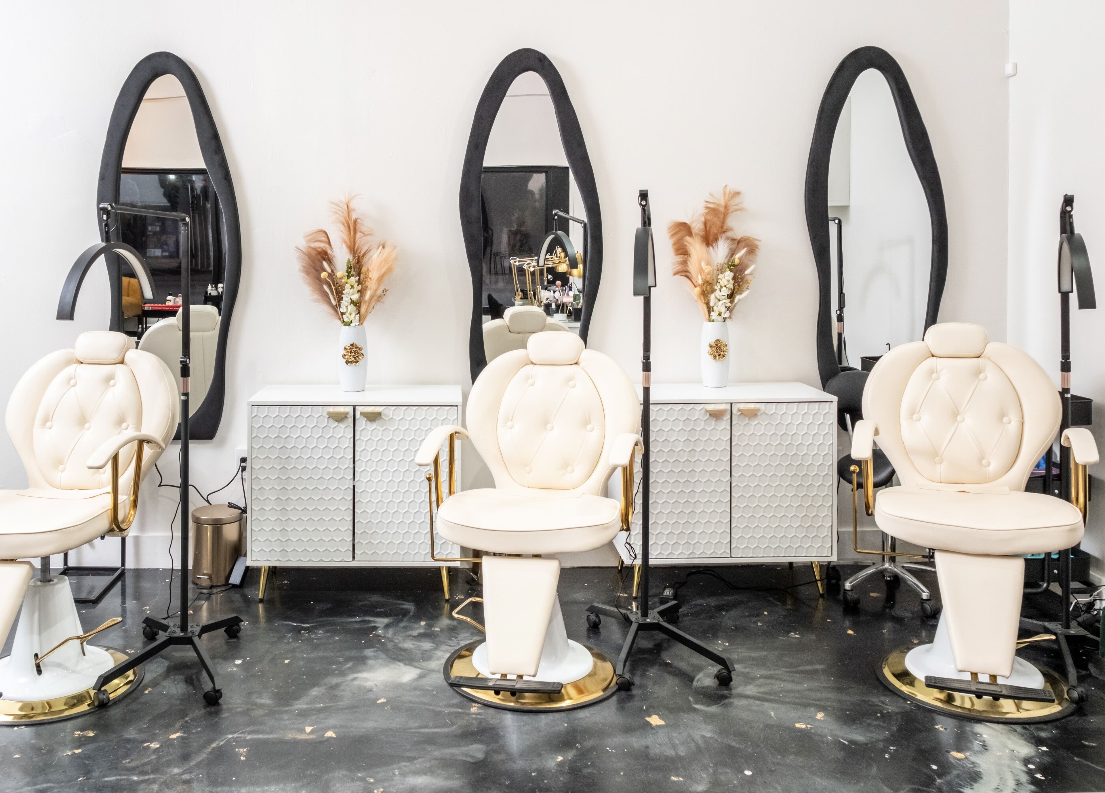 Interior de lujo en Beauty Style by Yanet, Miami, Florida, US con sillas de salón elegantes y espejos altos.