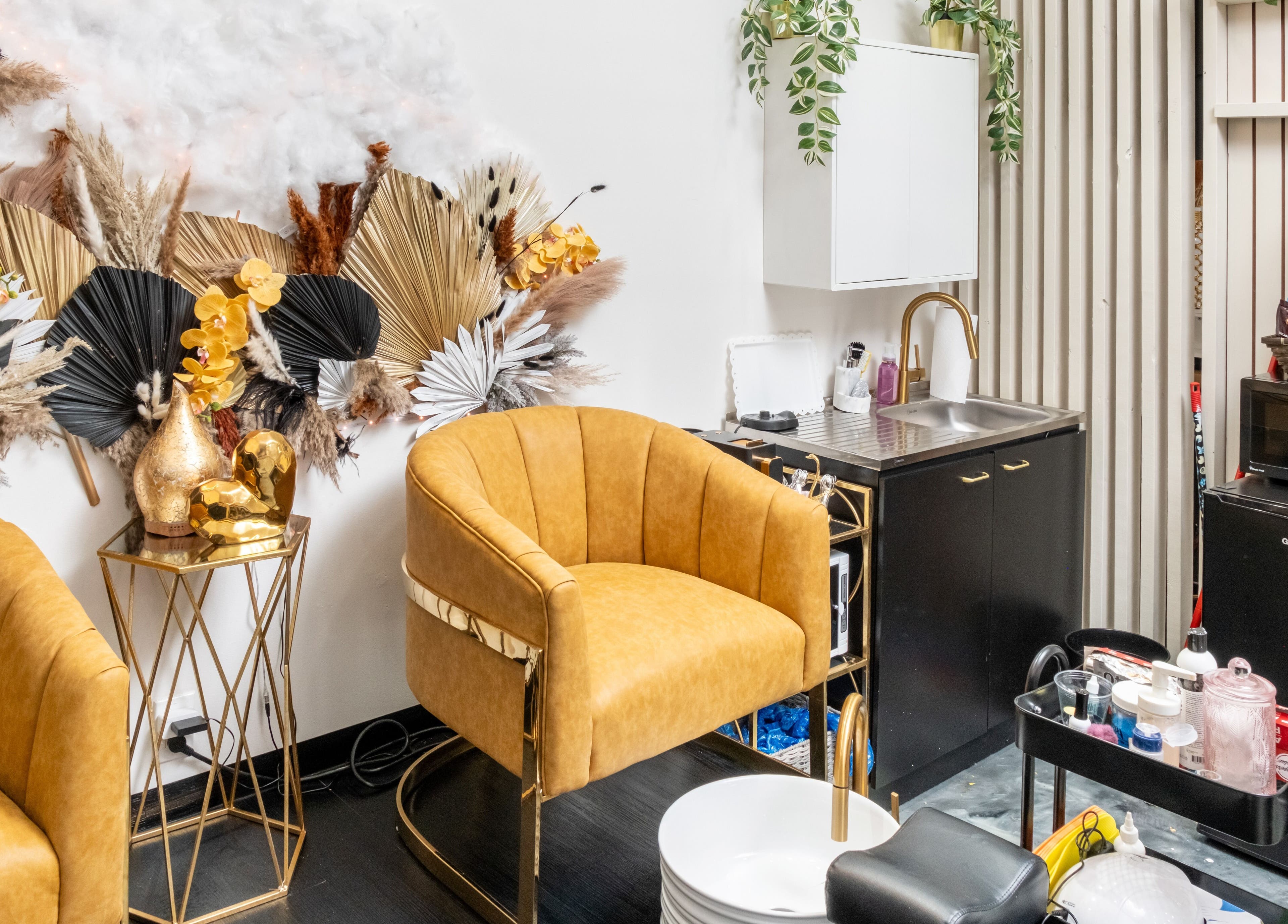 Moderno rincón de belleza en Beauty Style by Yanet, Miami, Florida, US con sillones dorados y decoración elegante.