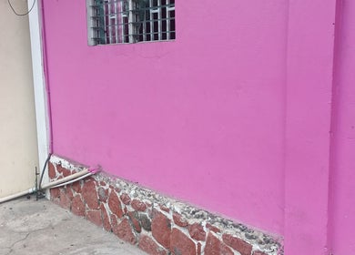 Bright pink wall of Merl's Beauty Section in Roseau, Saint George Parish, DM.