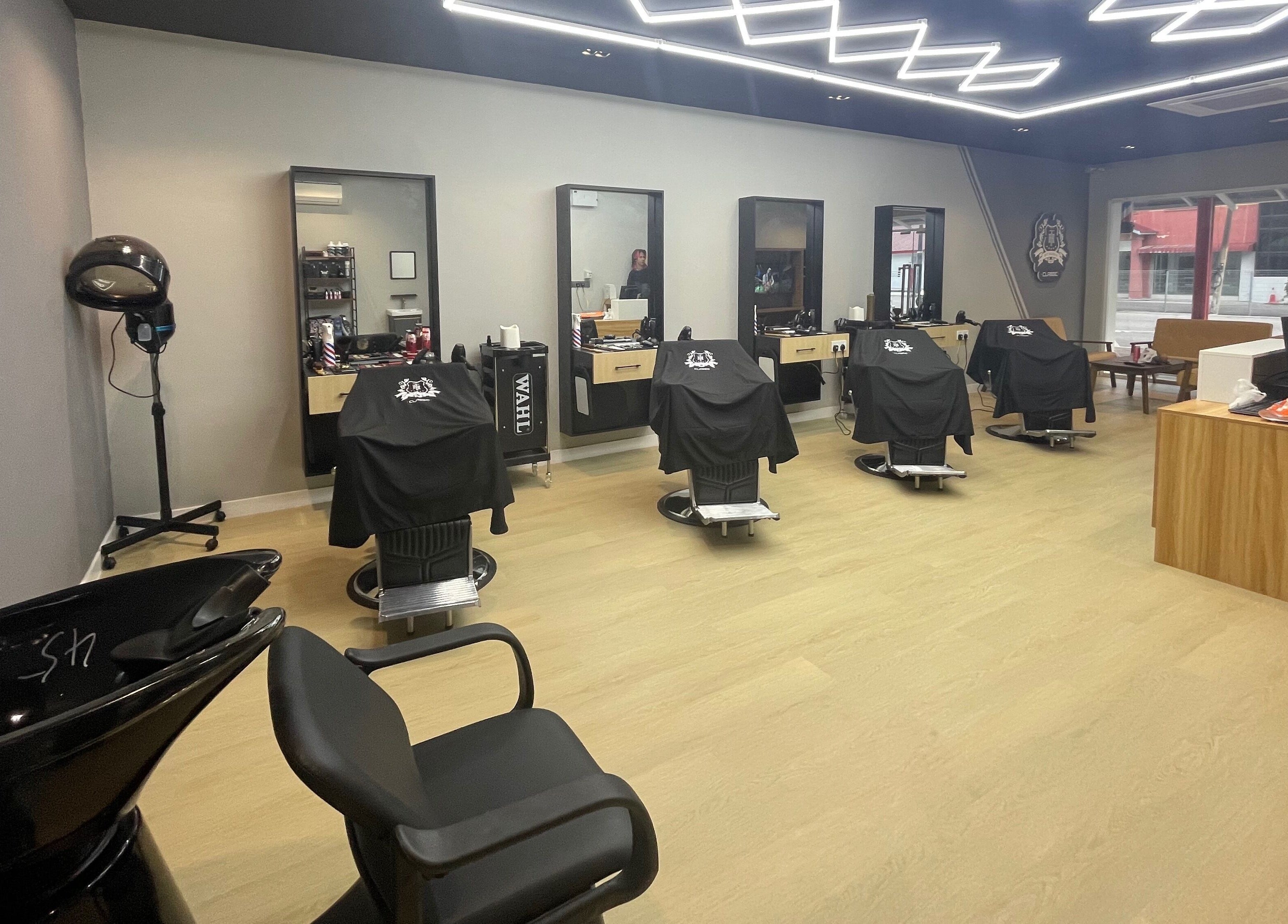 Chic interior of Hit Barber Classic Langkawi in Langkawi, Kedah, MY showcasing modern barber chairs and equipment.