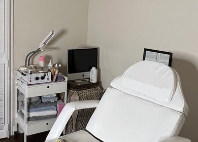 Nyeyeview treatment room in Hamilton, Ontario, CA featuring a white chair and skincare products.