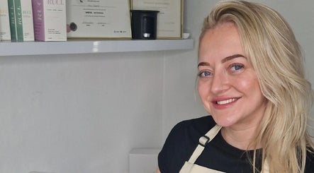 Smiling staff at Reform Skin Clinic, Cawood, England, showcasing certifications and products.