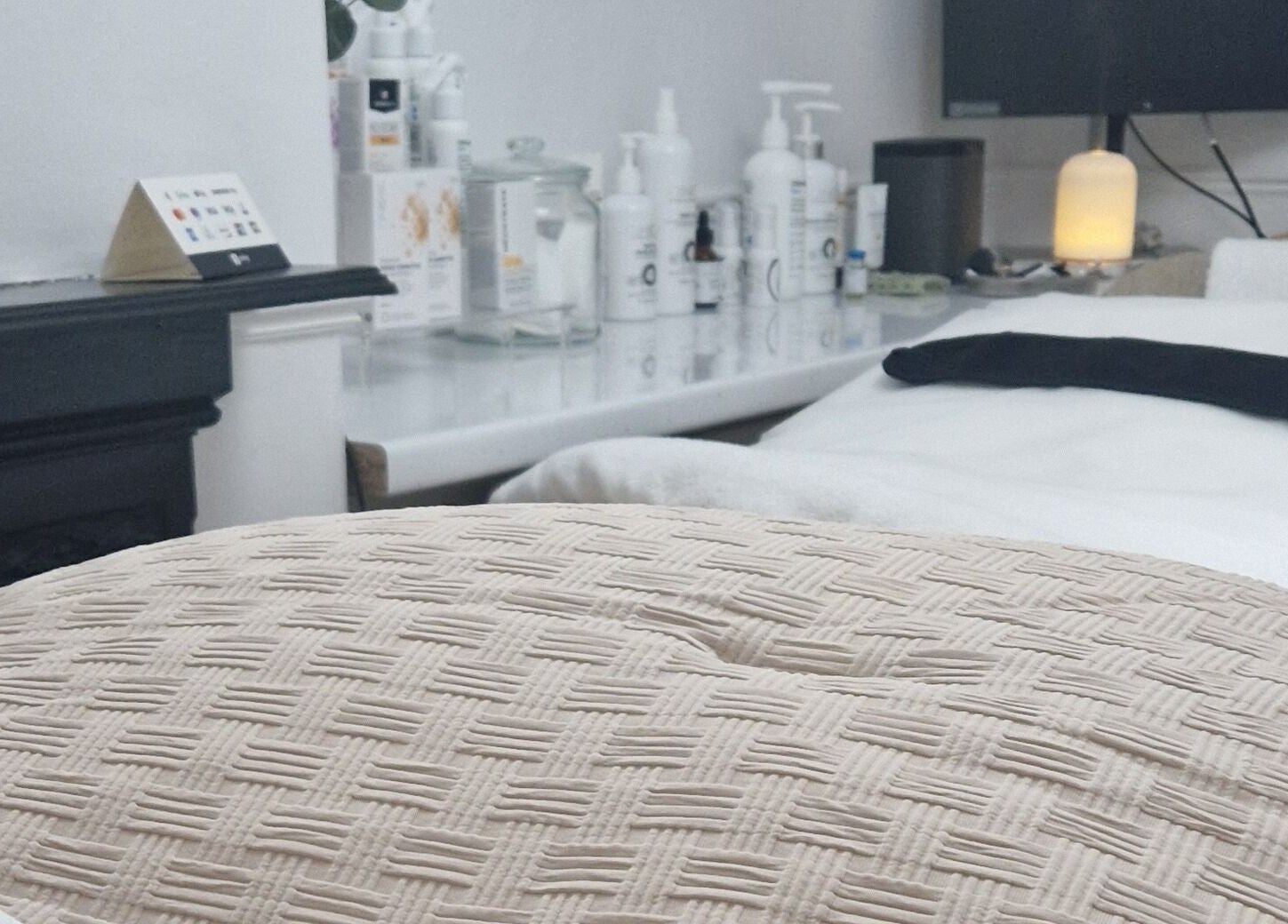 Relaxing treatment room at Reform Skin Clinic, Cawood, England, GB, featuring a plush bed and skincare products.