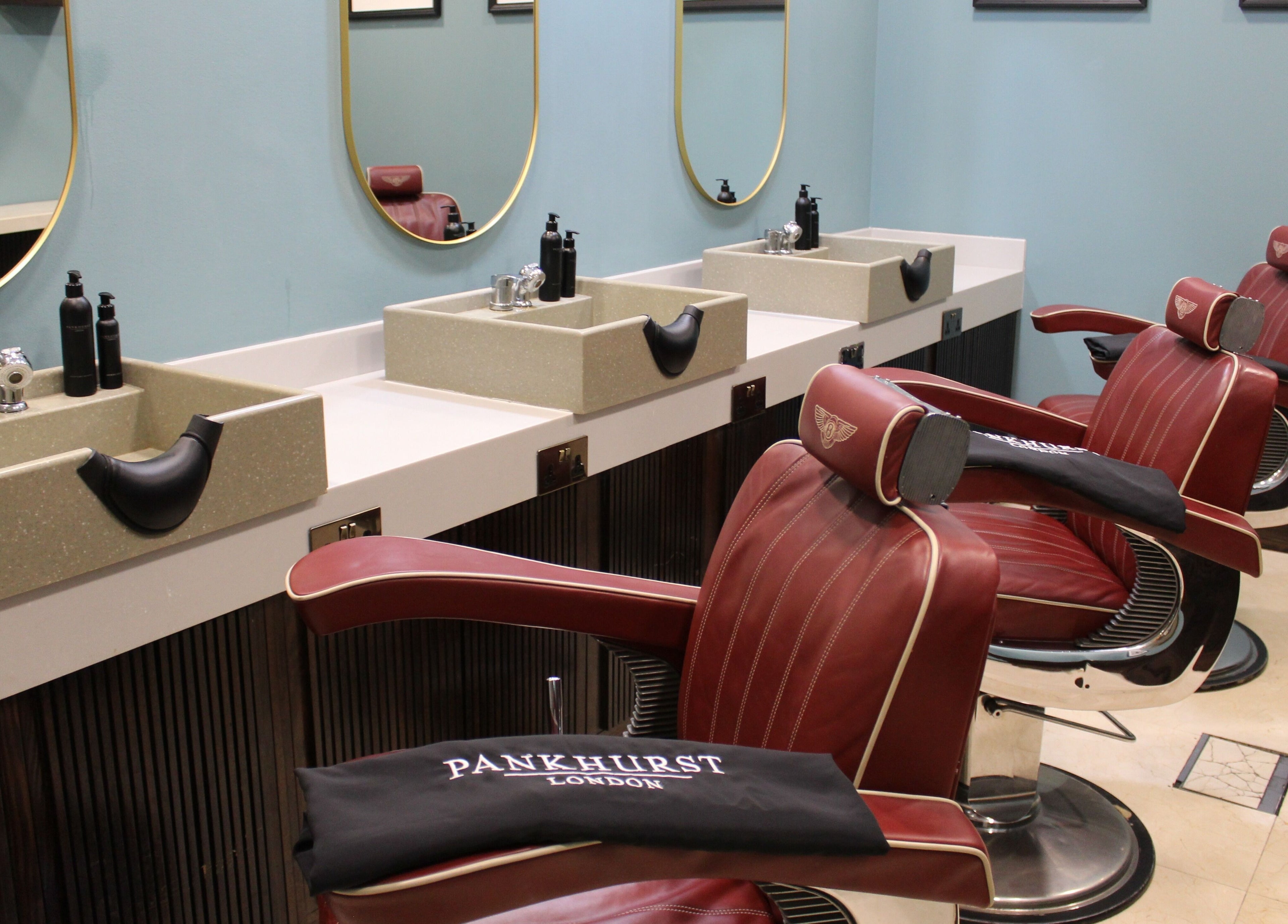 Stylish barber chairs at Pankhurst London, Dubai, Dubai, AE, showcasing luxury grooming ambiance.