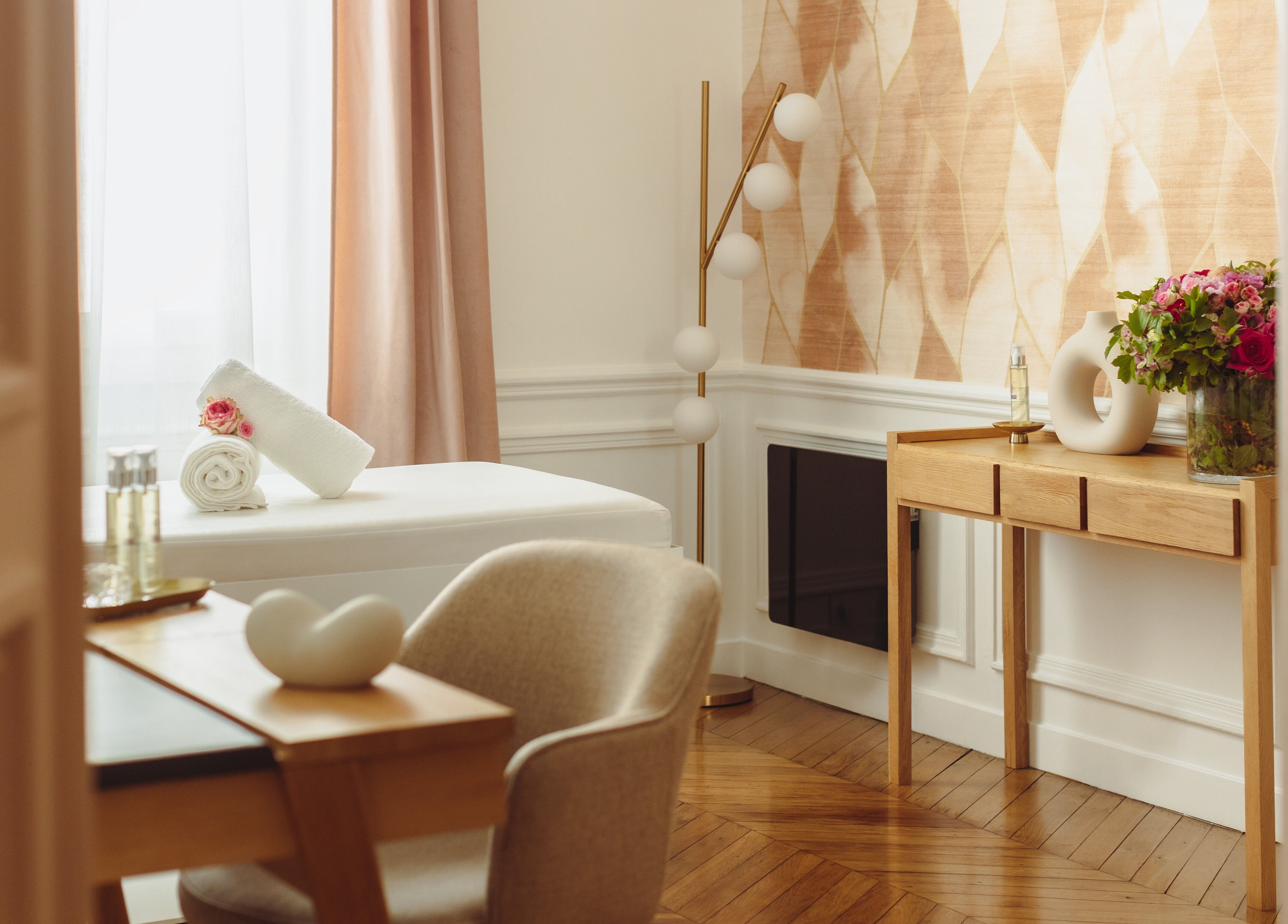 Salle de soin élégante au Centre Anne Cali, Paris, Île-de-France, FR, avec table de massage et déco apaisante.