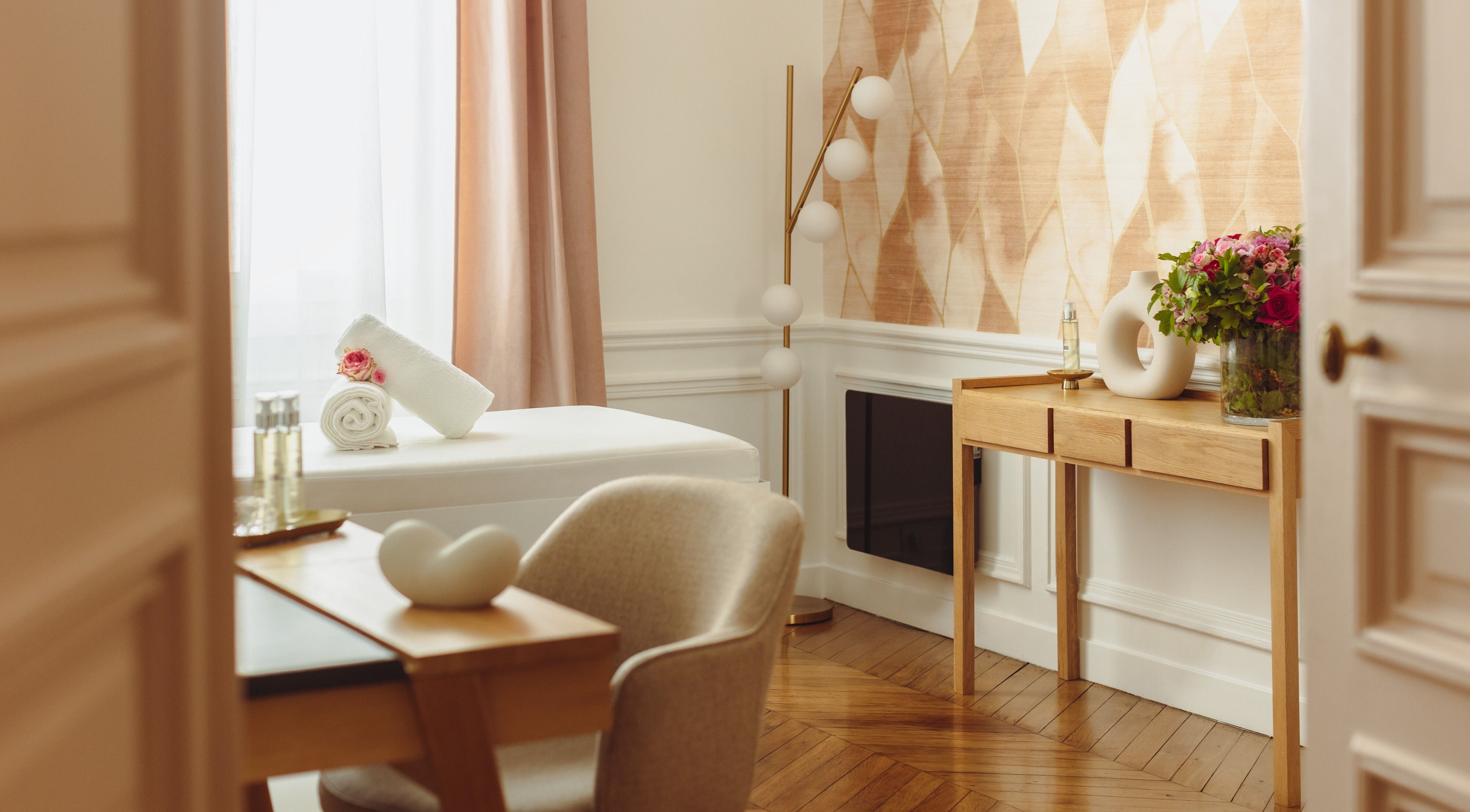 Salle de soin élégante au Centre Anne Cali, Paris, Île-de-France, FR, avec table de massage et déco apaisante.