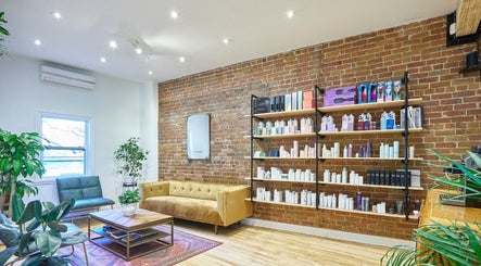 Intérieur moderne d'Osalon, Montréal, Québec, CA avec des produits beauté sur étagères et canapé confortable.