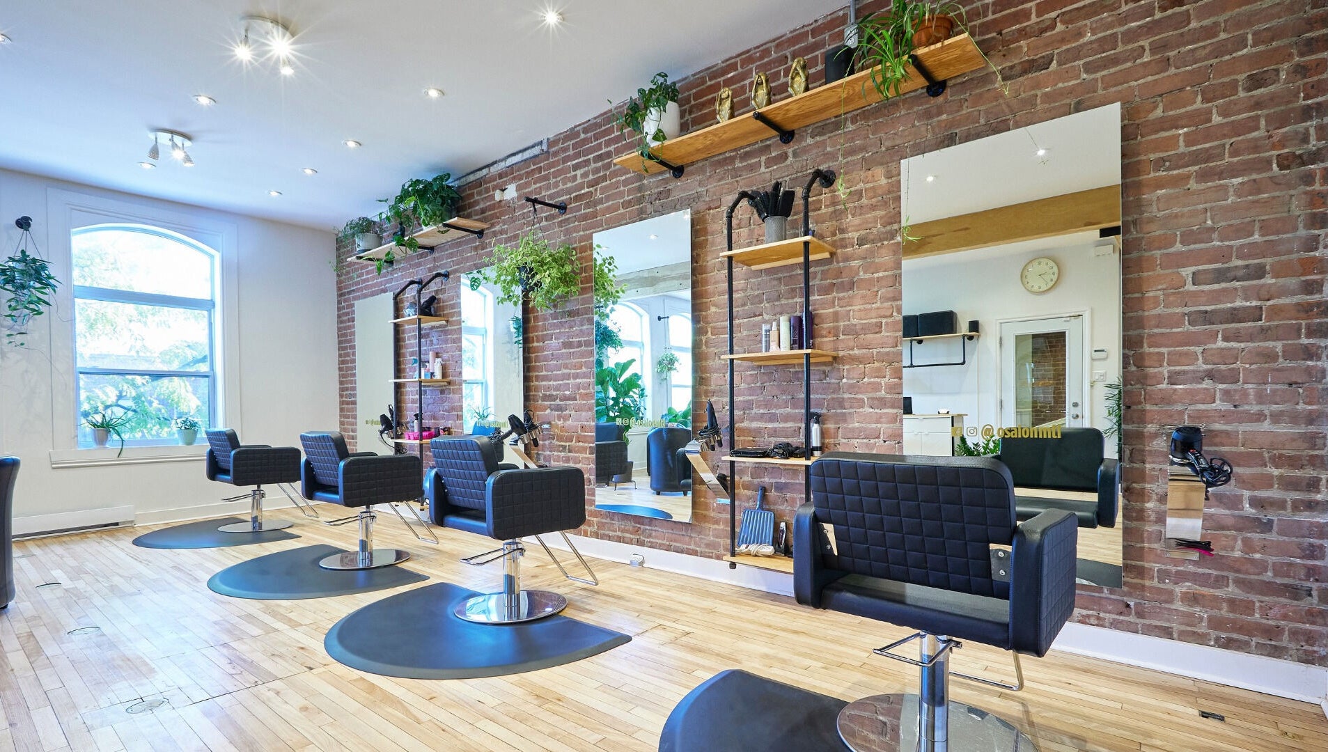 Intérieur moderne du salon O Salon, situé à Montréal, Québec, CA, avec des fauteuils élégants et un mur en briques.