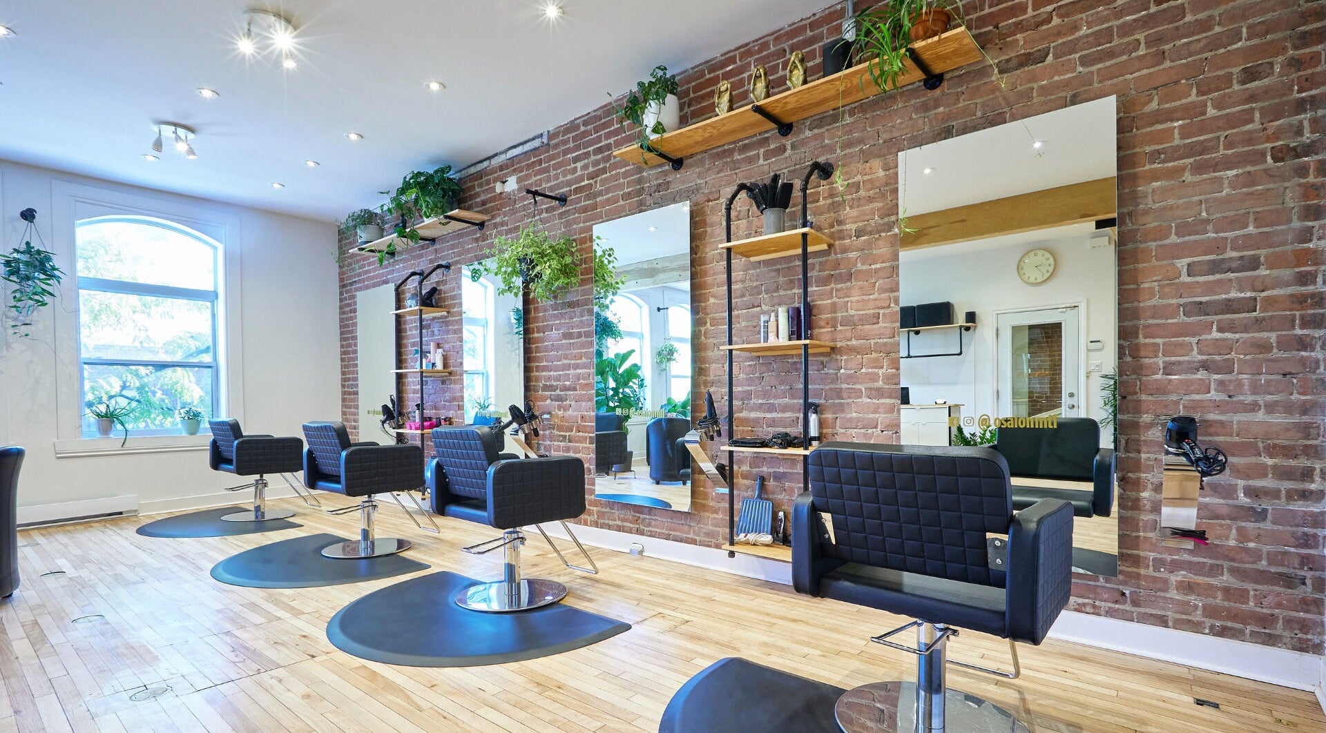 Intérieur moderne du salon O Salon, situé à Montréal, Québec, CA, avec des fauteuils élégants et un mur en briques.