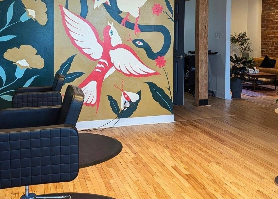 Intérieur moderne d'O Salon à Montréal, Québec, CA, avec murale colorée et chaises de coiffure.