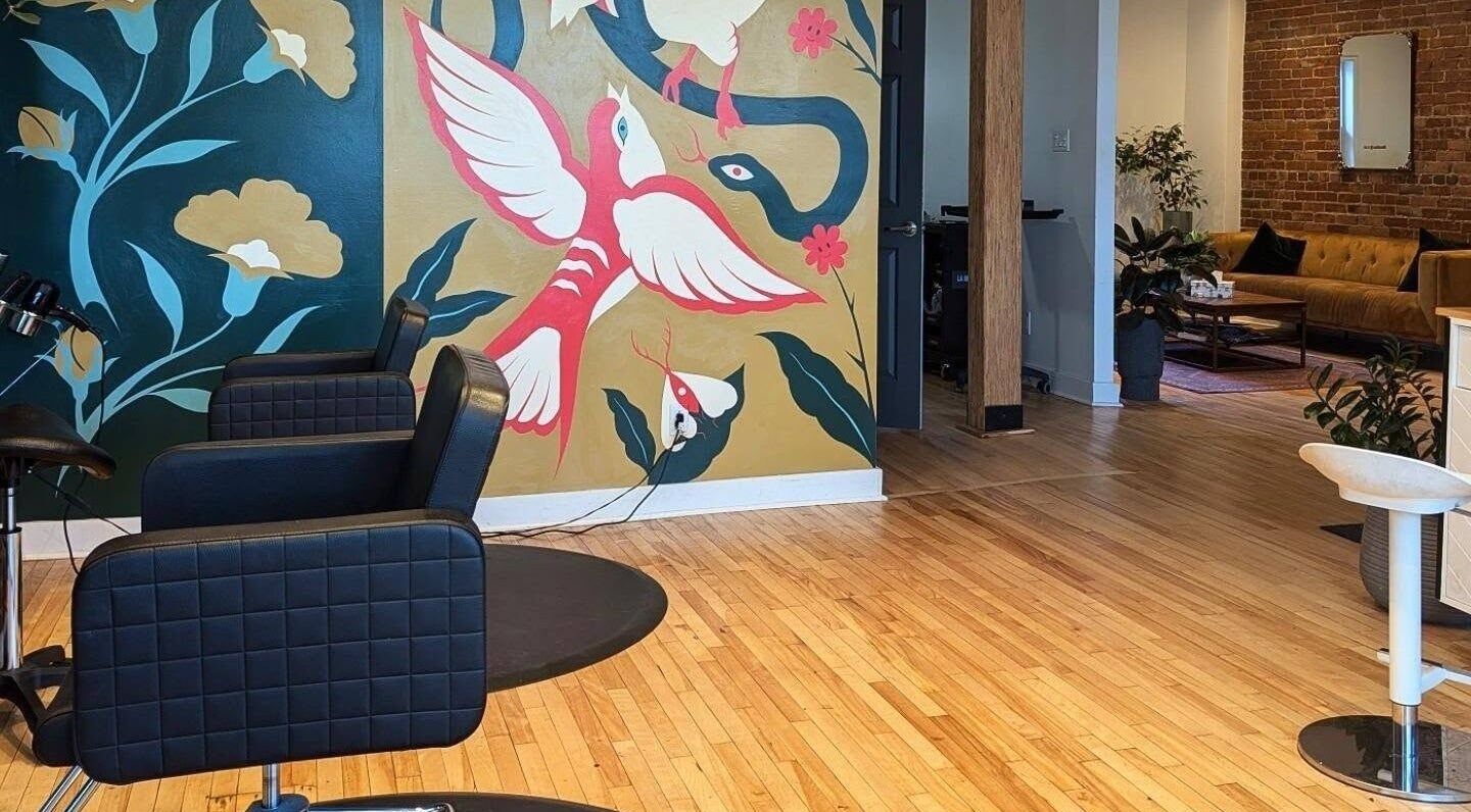 Intérieur moderne d'O Salon à Montréal, Québec, CA, avec murale colorée et chaises de coiffure.