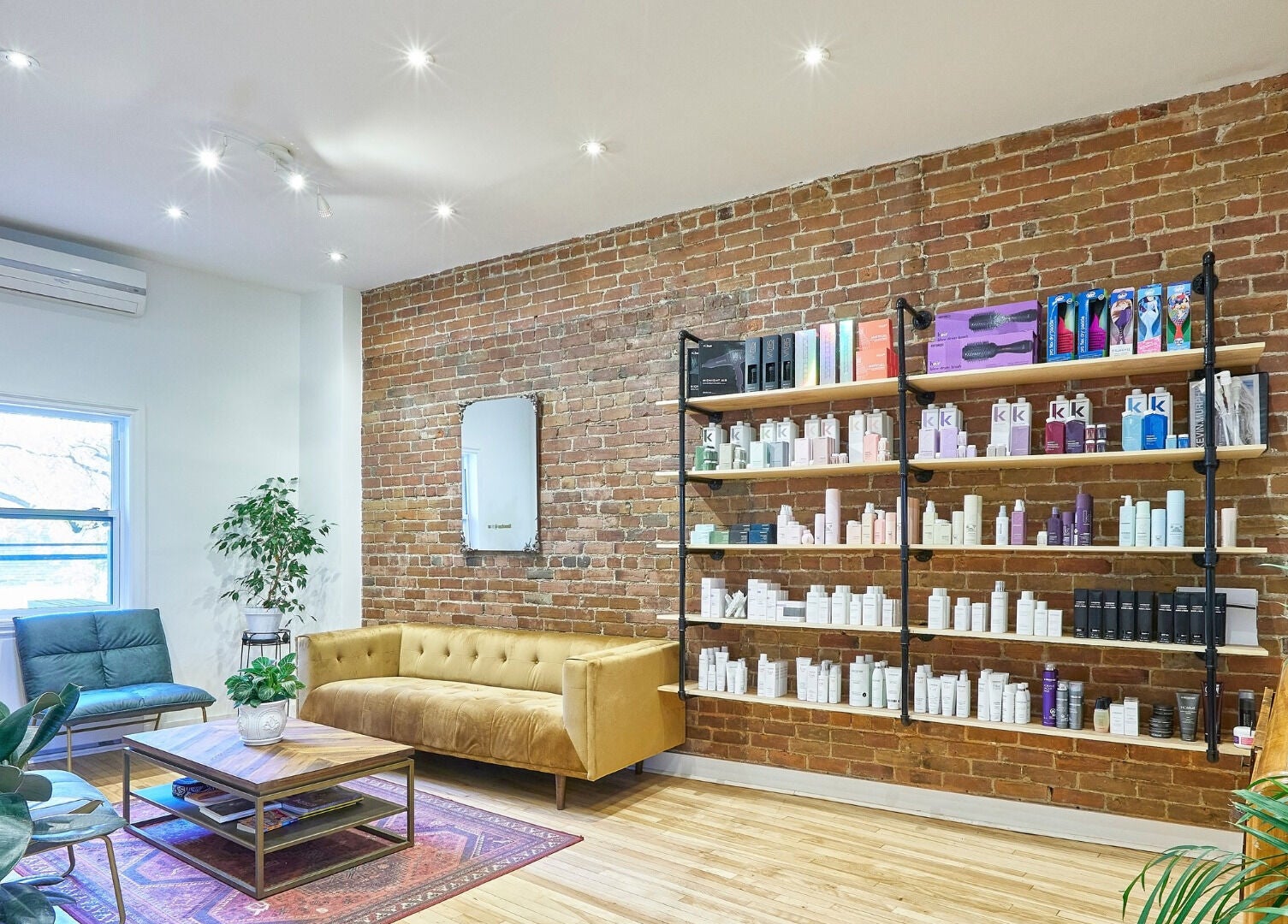 Intérieur élégant de O Salon à Montréal, Québec, CA avec un mur de briques et des produits de beauté.