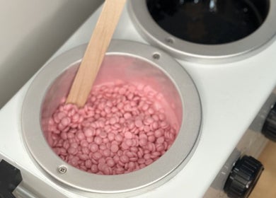 Pink wax beads in warmer at Bare Bottoms Wax Studio, Ottawa, Ontario, CA. Perfect for smooth skin.