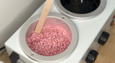 Pink wax beads in warmer at Bare Bottoms Wax Studio, Ottawa, Ontario, CA. Perfect for smooth skin.
