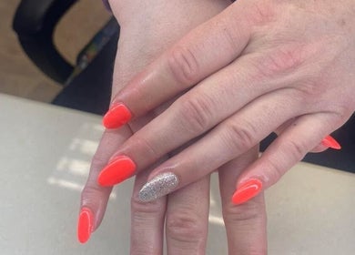 Vibrant gel nails at Tahiti Tan, Saint John, New Brunswick, CA with bright orange and glitter accents.