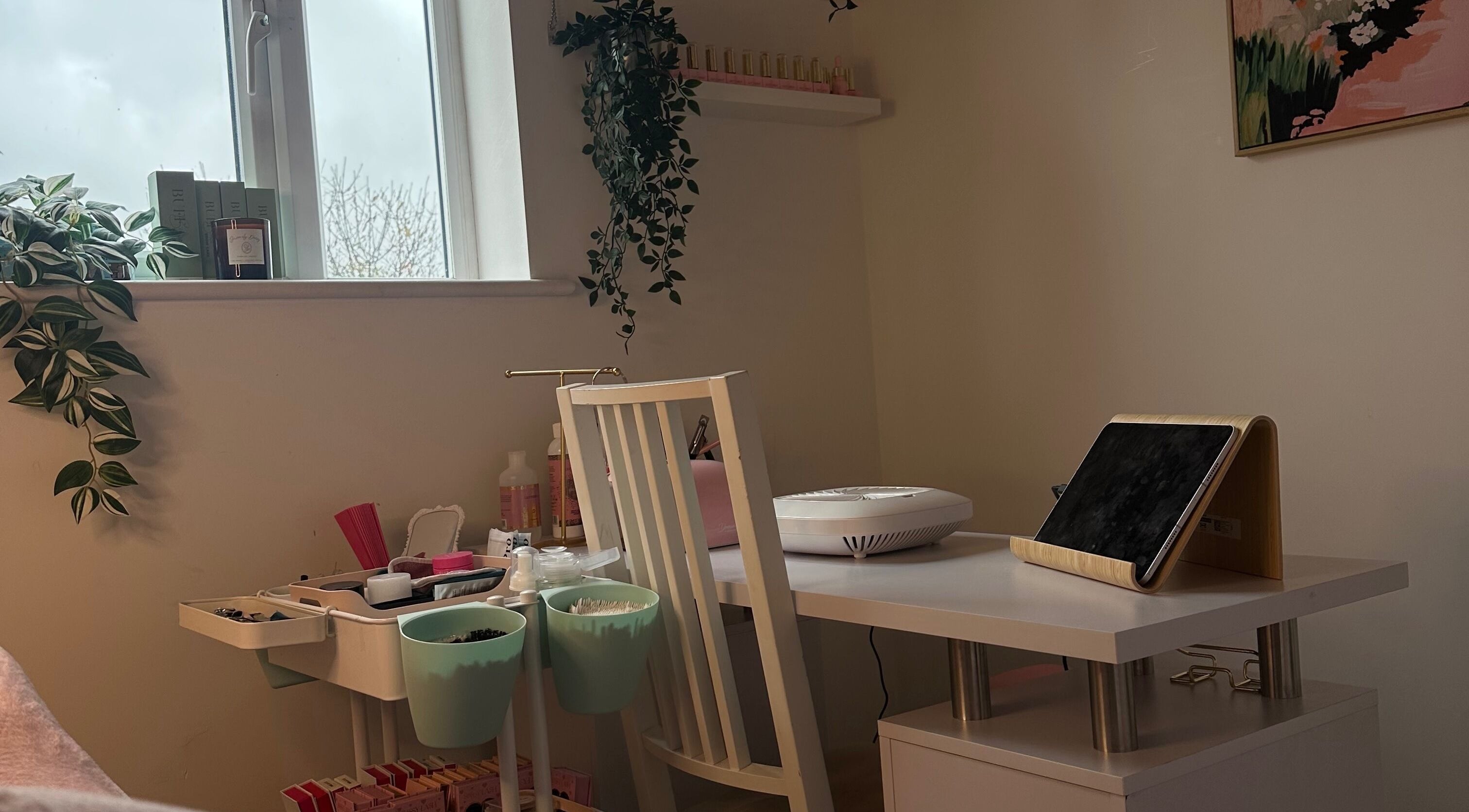 A cozy nail station at Lil Glow, Swindon, England, GB, with plants and beauty products on display.
