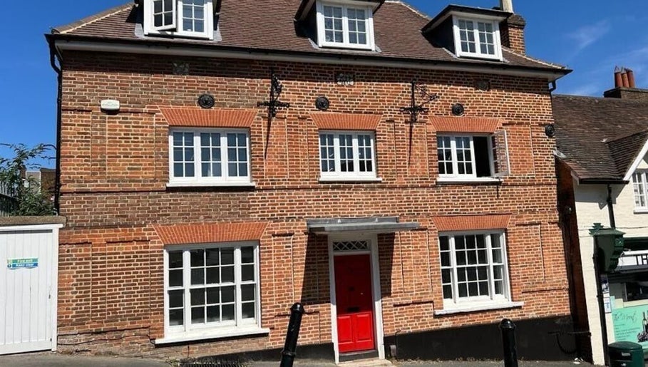 Front view of BONITA Spa's charming brick facade in Guildford, England, GB, featuring a vibrant red door.
