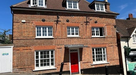 Rustic brick exterior of BONITA Spa, Guildford, England, GB, featuring a vibrant red door.