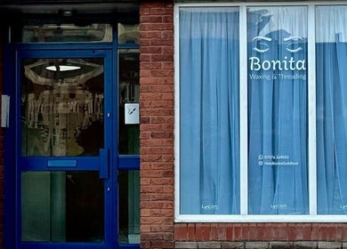 Entrance of BONITA Beauty Therapy in Guildford, England, GB with blue door and curtains.