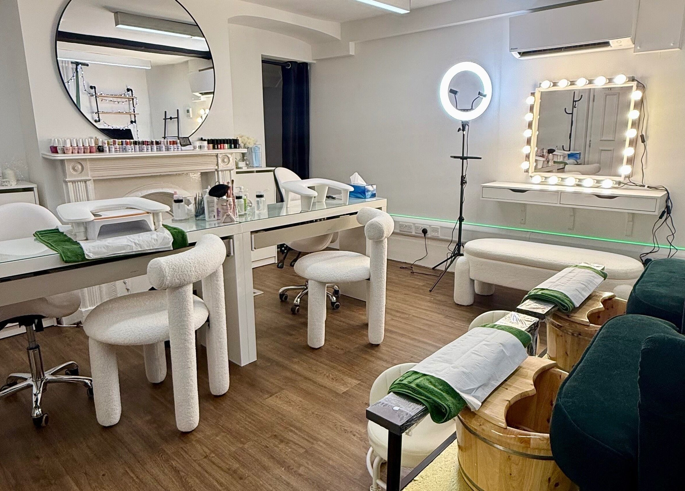 Elegant nail salon setup at Spa by BONITA, Guildford, England, GB featuring plush chairs and mirrored decor.