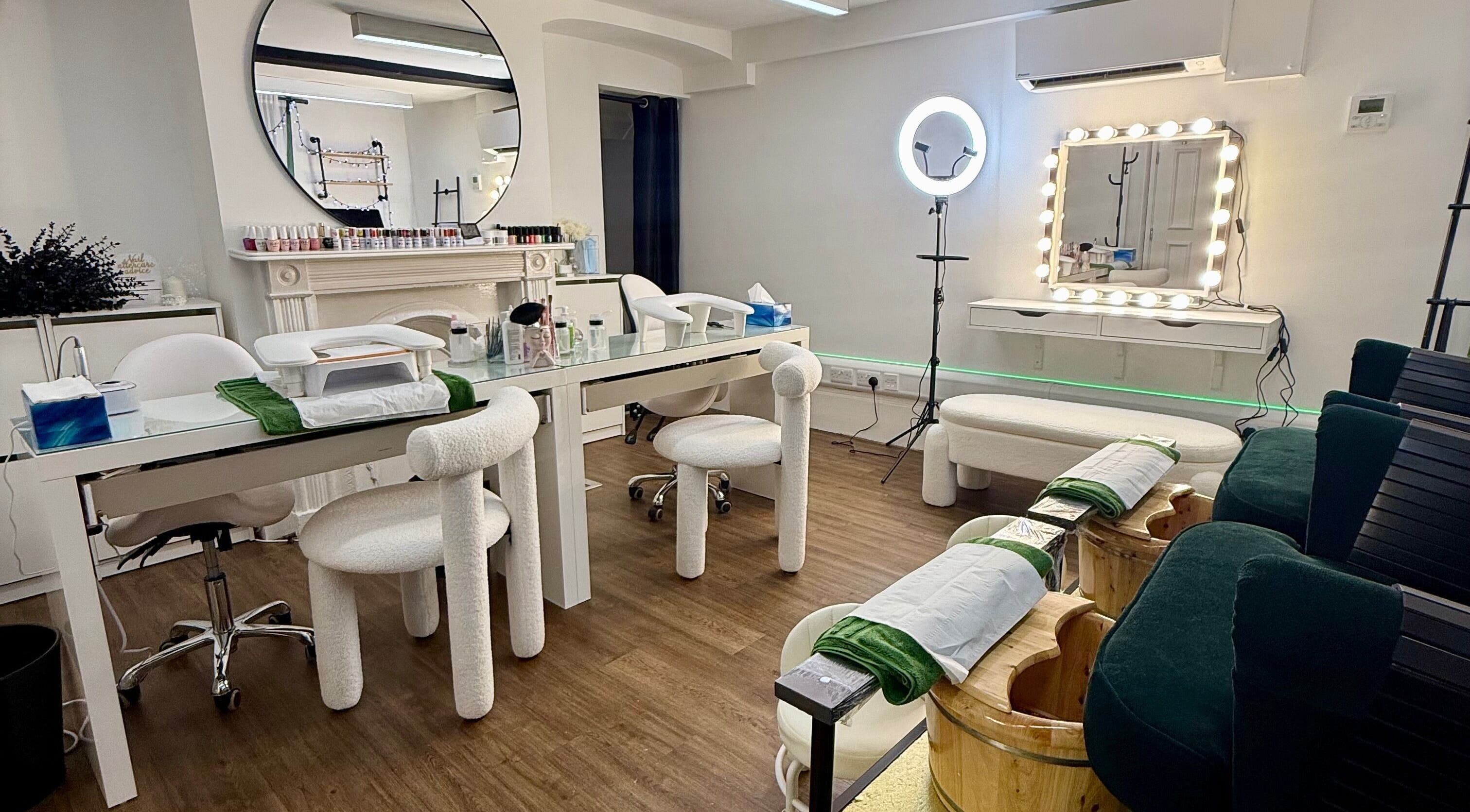 Elegant nail salon setup at Spa by BONITA, Guildford, England, GB featuring plush chairs and mirrored decor.