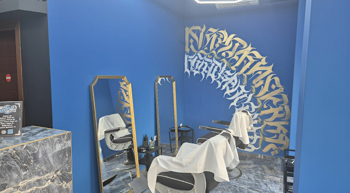 Μοντέρνος χώρος καλλωπισμού στο Hustler187, Βόλος, GR, με μπλε τοίχους και καλλιτεχνική διακόσμηση.