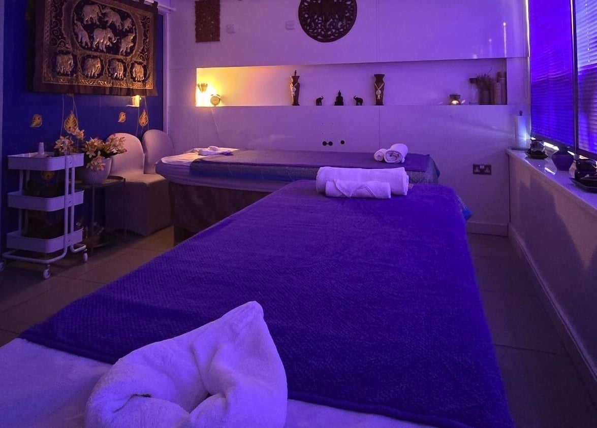 Relaxing massage room at Panlaan Spa, Weymouth, England, GB with calming blue lighting and cozy decor.