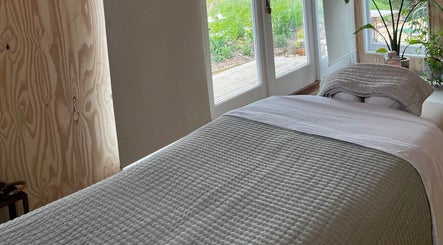 Tranquil massage room at Wild Coast Wellbeing, Kings Lynn, England, GB with natural light and cozy decor.