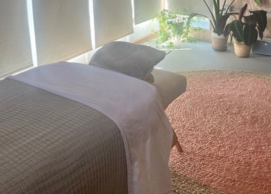 Cozy massage room at Wild Coast Wellbeing, Kings Lynn, England, GB with a massage table and plants.