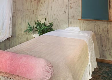 Serene massage room at Wild Coast Wellbeing in Kings Lynn, England, GB with cozy bed and calming decor.