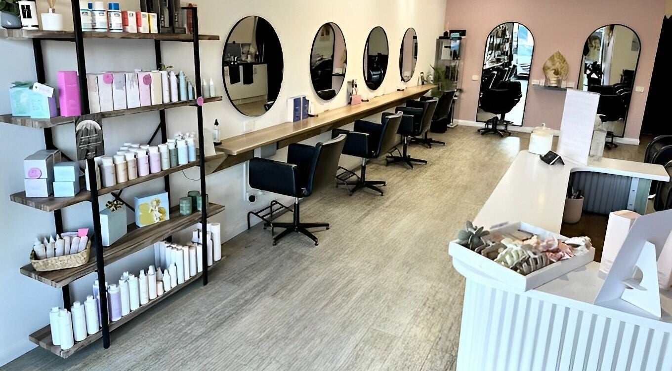 Modern salon setup at Kelly Hobbs Hair, Coffs Harbour, New South Wales, AU, featuring sleek stations and product display.