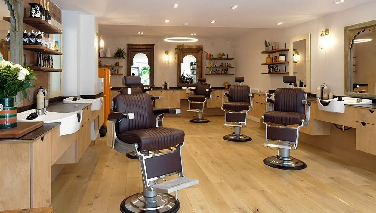Modern salon interior at time. in London, England, GB, featuring elegant styling chairs and sleek wooden decor.