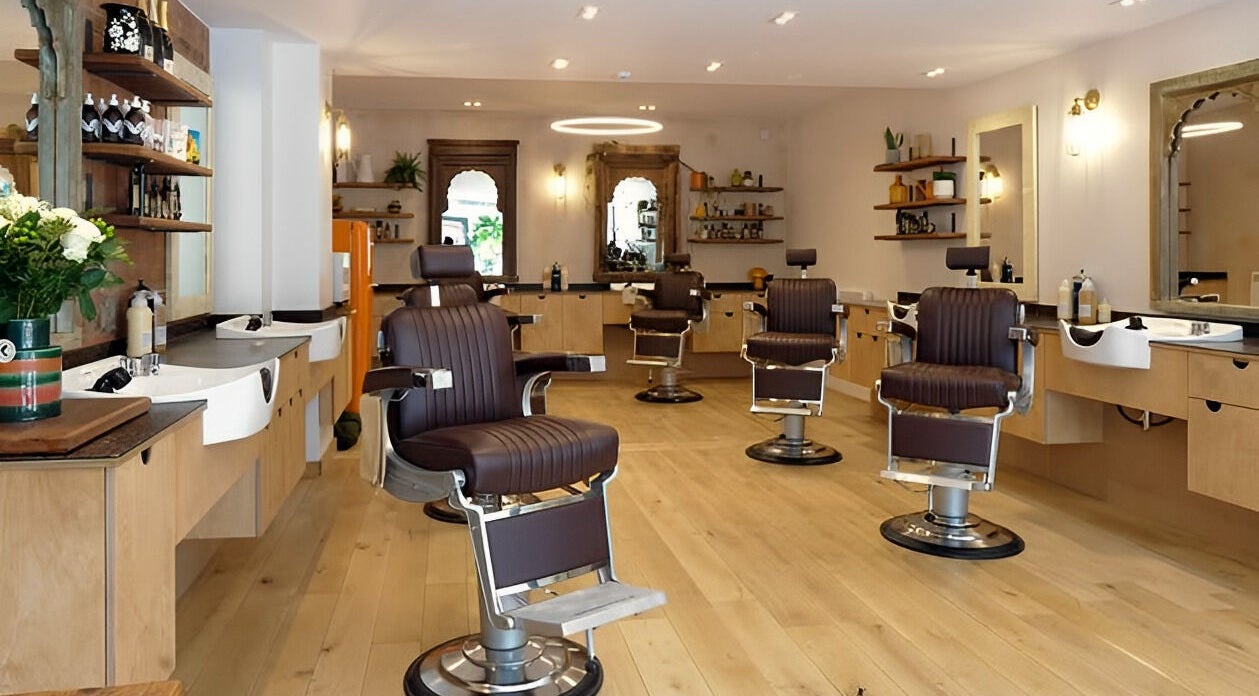 Modern salon interior at time. in London, England, GB, featuring elegant styling chairs and sleek wooden decor.