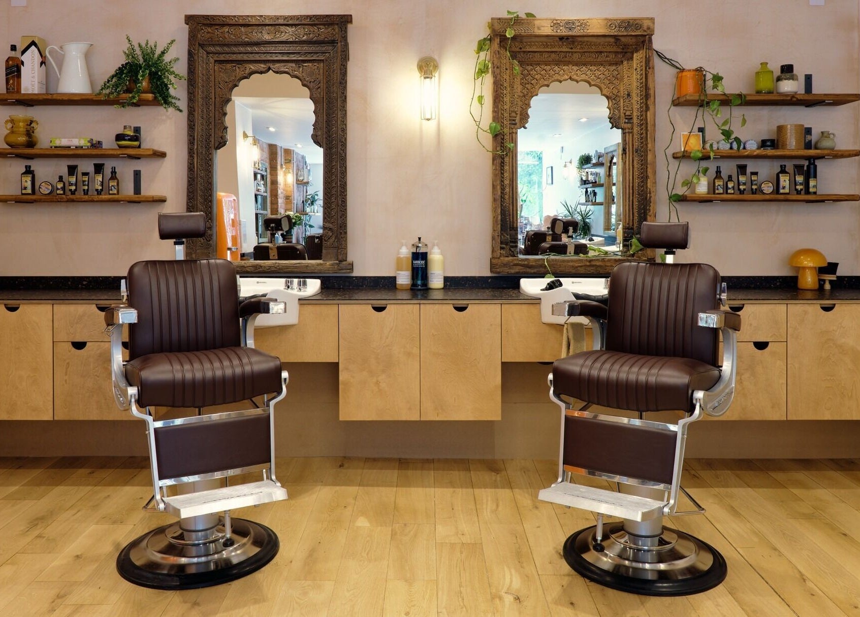 A stylish salon with leather chairs at time. in London, England, GB, featuring ornate mirrors and wooden shelves.