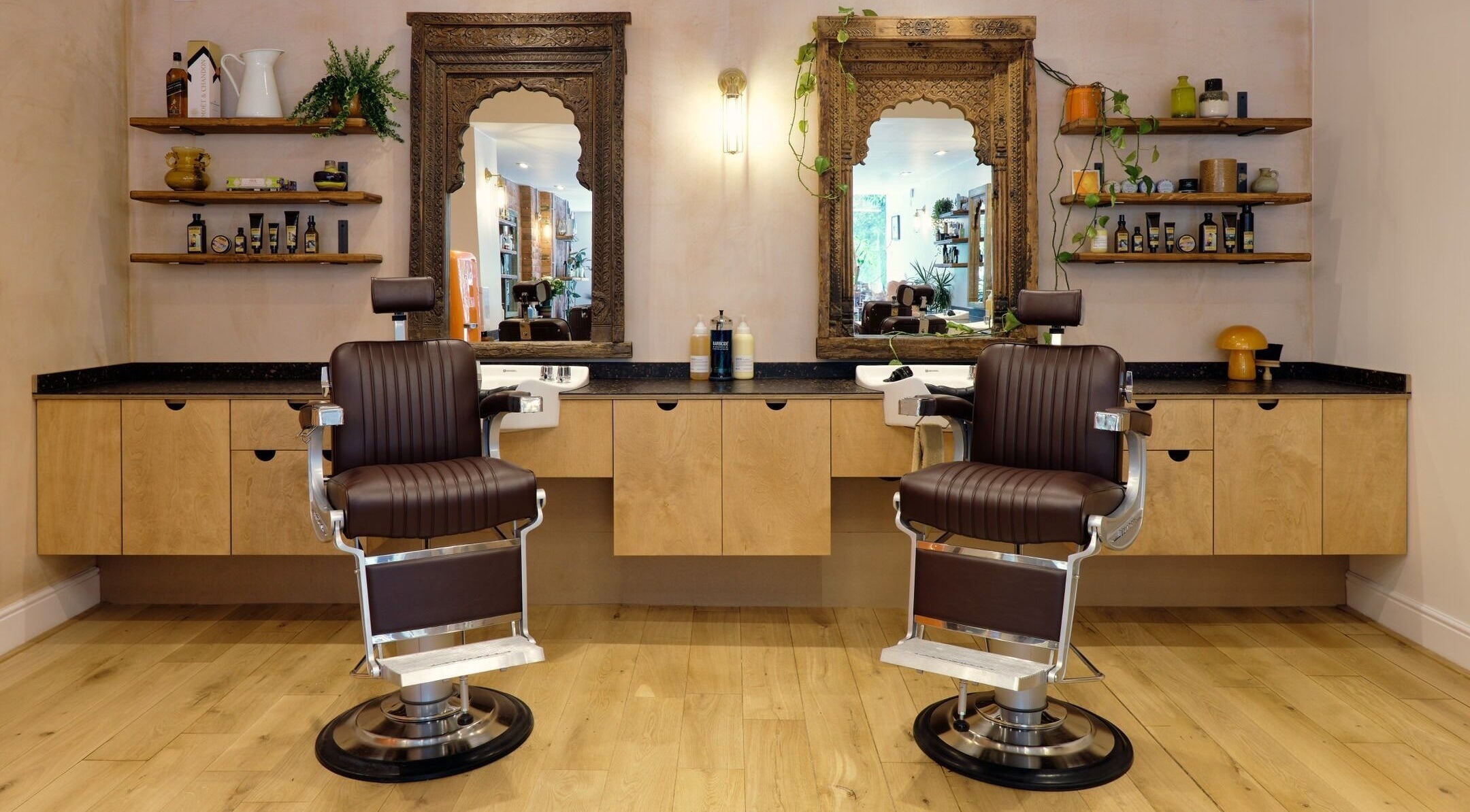 A stylish salon with leather chairs at time. in London, England, GB, featuring ornate mirrors and wooden shelves.
