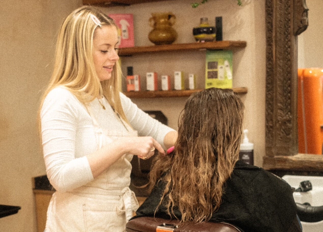 Stylist at time. salon in London, England, GB, expertly brushing a client's wet hair in a cozy setting.
